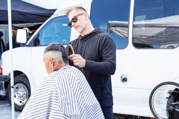 A man cutting a man's hair at a barber shop.